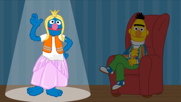 Grobi verkleidet als Prinzessin, Bert sitzt in einem Sessel daneben.